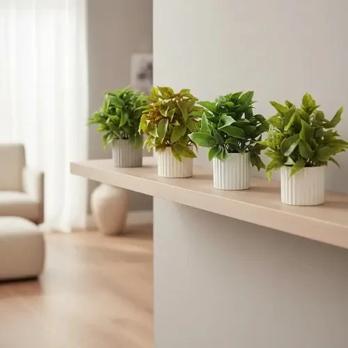 Mini artificial leafy plant in a white ribbed cylindrical pot