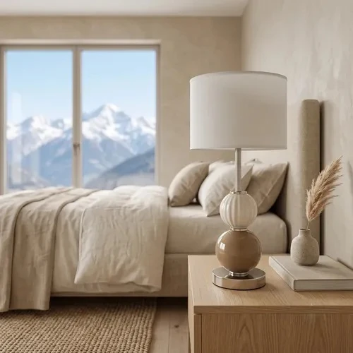 Table lamp with a stacked cream-and-tan ceramic sphere base and white drum shade