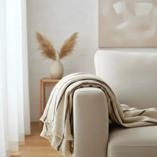 Lightweight beige throw with brown pinstripes and fringes